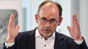 Mann mit Brille gestikuliert bei Präsentation