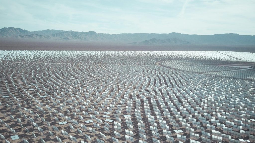 Luftaufnahme einer riesigen Solarfarm in einer Wüstenlandschaft, die die Technologie für erneuerbare Energien einfängt.
